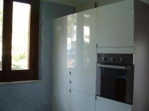 una cocina con armarios blancos y una ventana en Villa 2M a 50 metri dal mare, en San Vito lo Capo