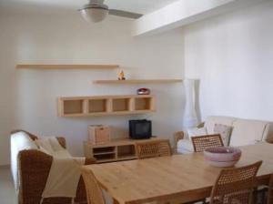 a living room with a wooden table and chairs at Villa 2M a 50 metri dal mare in San Vito lo Capo