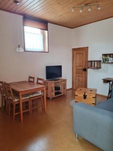 a living room with a table and a tv at Fewo Pfalzwohnung in Ellerstadt