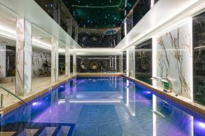 a swimming pool in a building with a star ceiling at Villa Vis a Vis in Trzęsacz
