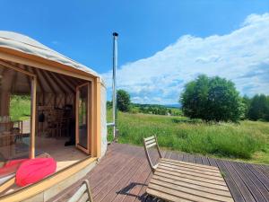 a yurt with a chair and a wooden deck at Ałabajka in Wleń