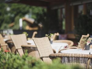 a group of chairs and tables in an outdoor restaurant at Hotel Brötz in Rasùn di Sotto