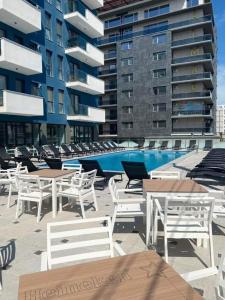 un gruppo di tavoli e sedie accanto a un edificio di Summer Smile by Euxin Accomodations a Năvodari