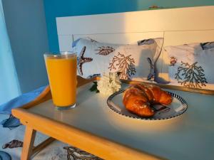a table with a glass of orange juice and a croissant at Summer Smile in Năvodari