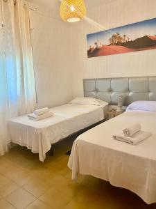 a room with two beds with towels on them at O Sole Mio in Albir