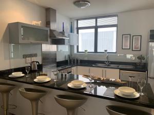 una cucina con piano di lavoro, sedie e bicchieri di City Penthouse Kapstadt a Città del Capo