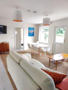 uma sala de estar com um sofá branco e uma mesa em Crow's Nest Glandore - 3 - Self Catering em Glandore