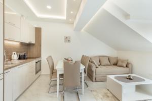 een keuken en een woonkamer met een bank en een tafel bij Apartmani Vasiljević in Herceg-Novi