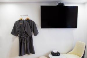 a black robe hanging on a wall next to a chair at Number 25 Hotel Jecheon in Jecheon