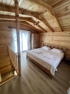 1 dormitorio con 1 cama grande en una casa de madera en FNM Luxury BUNGALOW’S & Restaurant, en Kumluca