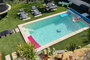 an overhead view of a swimming pool with chairs and a yard at Magnifique villa avec piscine et vue panoramique in La Destrousse