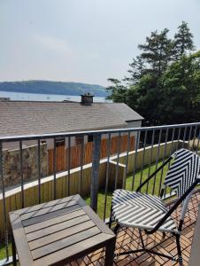 a deck with a table and a chair on a balcony at Crow's Nest Glandore - 3 - Self Catering in Glandore