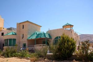 a large building with a green roof in the desert at B&B Petra Fig Tree Villa in Wadi Musa