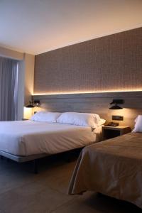 リョレート・デ・マルにあるHotel Metropolのベッド2台とヘッドボード付きのホテルルームです。