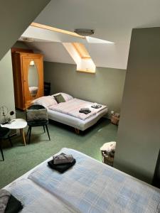 1 dormitorio con 2 camas, mesa y silla en Apartmán Dlouhá, en Bechyně