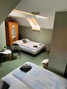 sypialnia z dwoma łóżkami, stołem i krzesłem w obiekcie Apartmán Dlouhá w mieście Bechyně