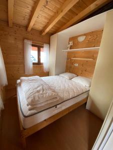 a bedroom with a bed in a wooden cabin at Chalet Rent Porlezza in Porlezza