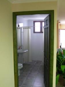 een badkamer met een toilet, een wastafel en een deur bij Loft en planta baja en Ciudad Rodrigo in Ciudad-Rodrigo