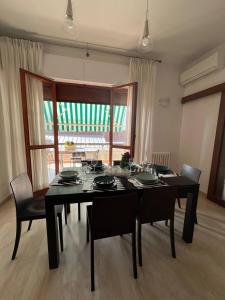 uma mesa de jantar preta com cadeiras e uma janela em A casa di Nonna em Pescara