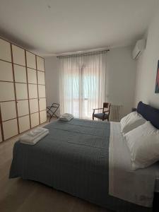 um quarto com uma cama grande e uma janela em A casa di Nonna em Pescara