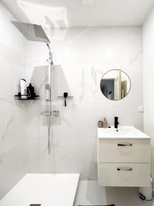 baño blanco con ducha y lavamanos en Appart'Hôtel Le Jaurès - Jardin privé et Netflix, en Belfort