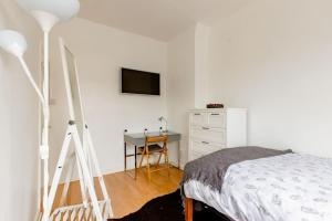 a bedroom with a bed and a desk and a television at Bright and Airy Double room in Norbury in Streatham Vale