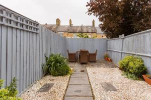a backyard with a fence and a table and chairs at Bright and Airy Double room in Norbury in Streatham Vale