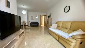 a living room with a couch and a flat screen tv at Amplio apartamento en centro in Denia