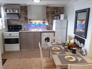 a kitchen with a table and a white refrigerator at Stone Clock's House in Nafpaktos