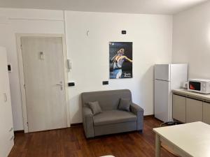 ein Wohnzimmer mit einem Stuhl und einem Kühlschrank in der Unterkunft Bergamo Center in Bergamo