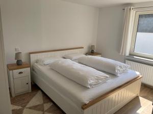 uma cama com duas almofadas num quarto em Ferienwohnung Hildfeld KORS em Winterberg