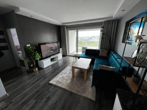 a living room with a blue couch and a tv at Przytulny apartament do wynajęcia in Reda