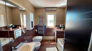 y baño con aseo, lavabo y espejo. en Bella Vista Apartments, en Umag