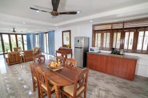 a kitchen and dining room with a wooden table and chairs at La Belle Residence Self Catering Accommodation in Beau Vallon