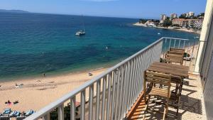 balkon z widokiem na plażę i łódź w obiekcie Le Face à La Mer w Ajaccio