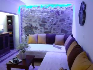 sala de estar con sofá y pared de piedra en Stone Clock's House, en Nafpaktos