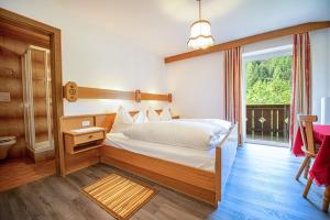 a bedroom with a bed and a large window at Apartments Jasmin in Selva di Val Gardena