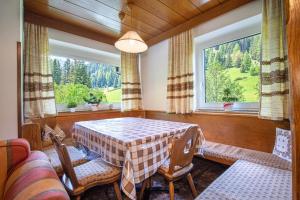 comedor con mesa, sillas y ventana en Apartments Jasmin, en Selva di Val Gardena