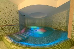 een jacuzzi in een badkamer met blauwe verlichting bij Hotel Terme Oriente - Beach & SPA in Ischia