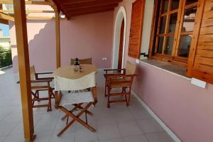 une chambre avec une table et des chaises sur une terrasse couverte dans l'établissement Tranquility Base, à Néapolis