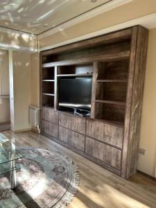 uma sala de estar com um grande centro de entretenimento com uma televisão de ecrã plano em 1 Bedroom stylish apartment in TSUM em Tashkent