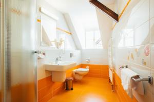 een badkamer met een wastafel, een toilet en een raam bij Sv. Hubertus in Český Krumlov