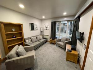 a living room with a couch and a tv at Quaysiders Club in Ambleside