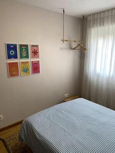 a bedroom with a bed with a blue and white comforter at Apartamento Solpor in Vilagarcia de Arousa