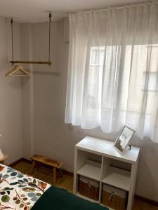 a bedroom with a bed and a table with a laptop at Apartamento Solpor in Vilagarcia de Arousa