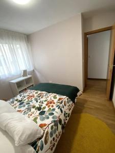 a bedroom with a bed with a colorful comforter at Apartamento Solpor in Vilagarcia de Arousa