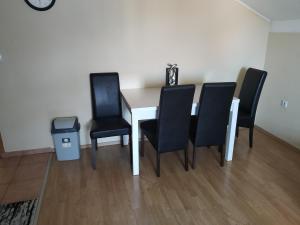 mesa de comedor con 4 sillas negras en Apartment Edin, en Bihać
