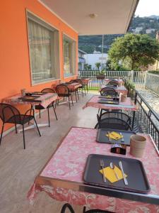 un gruppo di tavoli e sedie su un patio di Albergo Villa Mimosa a Torbole