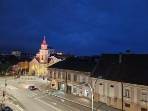 una calle de la ciudad con un edificio con una torre de reloj en Stan na dan Ilvento 2, en Vršac