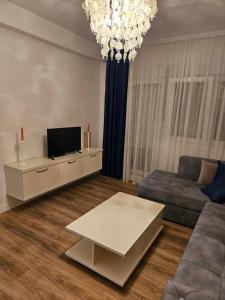 a living room with a couch and a tv at Stan na dan Ilvento 2 in Vršac